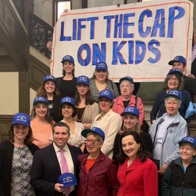 Lift the Cap supporters pose on the steps of the Massachusetts State House