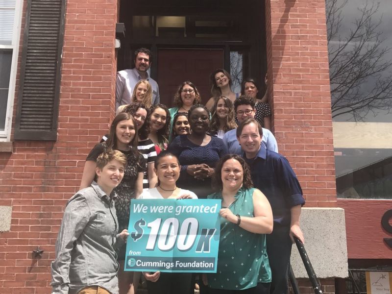 Group of BARCC staffers in front of office building holding sign that says We were granted $100K from Cummings Foundation