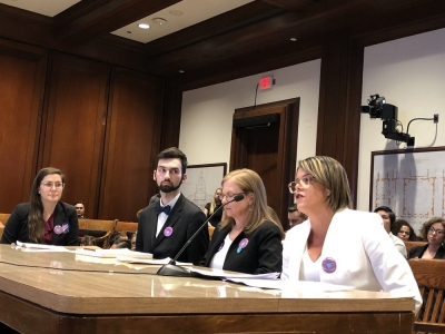 BARCC staffer speaks into microphone at Healthy Youth Act hearing
