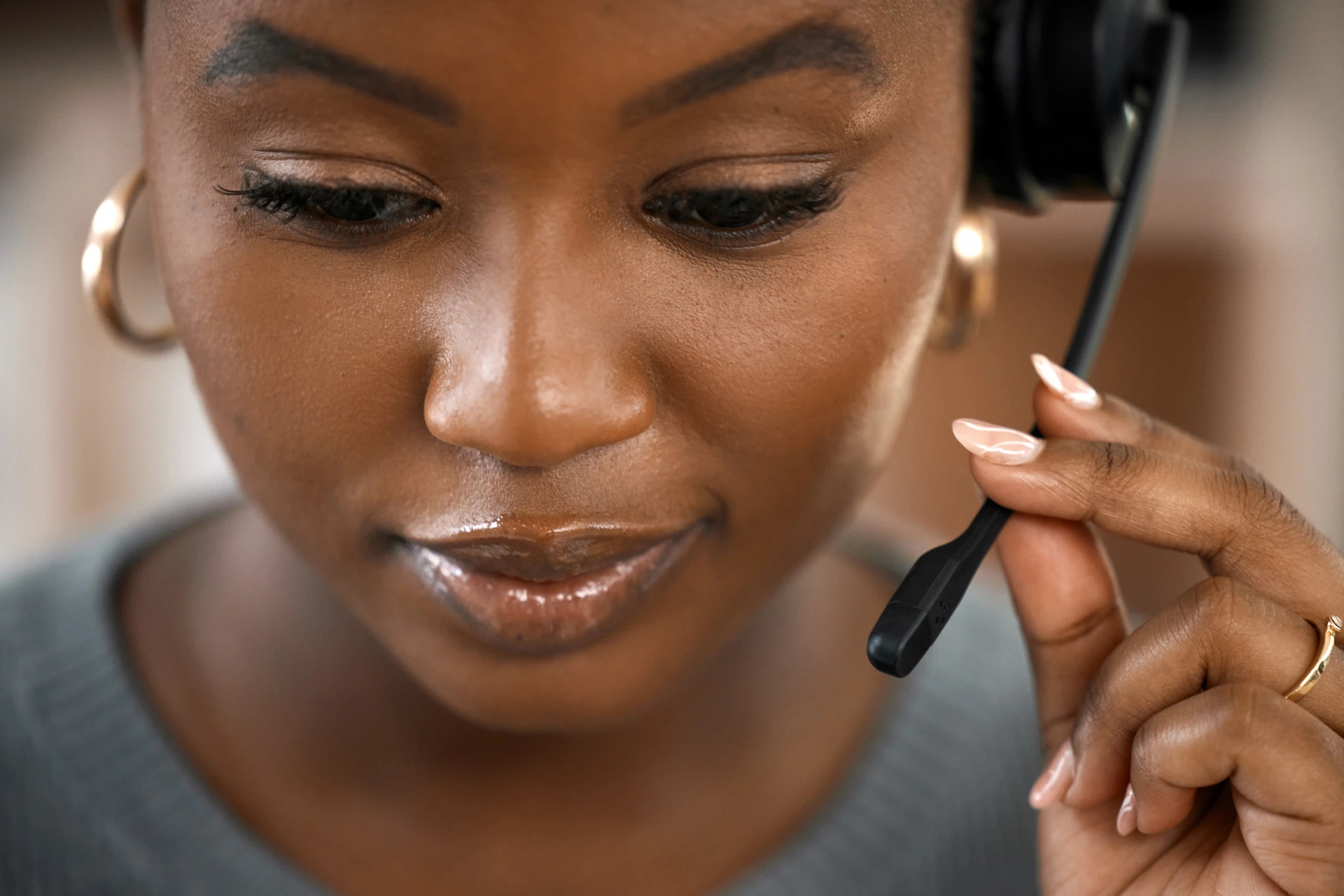 A women on a headset with a slight smile on her face showing she is kind and supportive