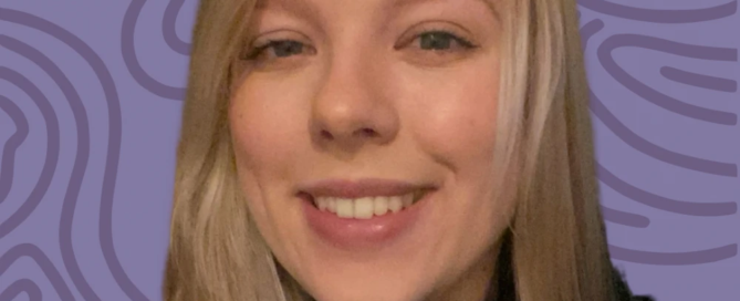 A smiling person with long blonde hair in a black top stands against a purple, wavy patterned background, embodying the warmth and support found at Boston's Rape Crisis Center.