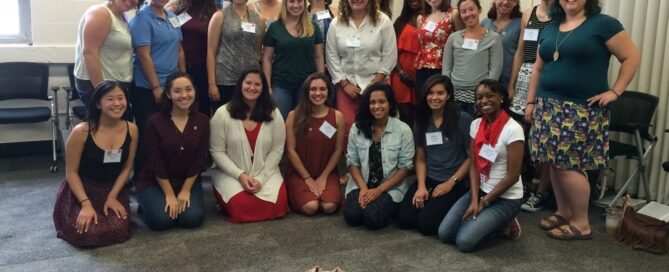 A group of people posing indoors with a small dog in front celebrates the compassionate team dedicated to providing essential services at the local rape crisis center.