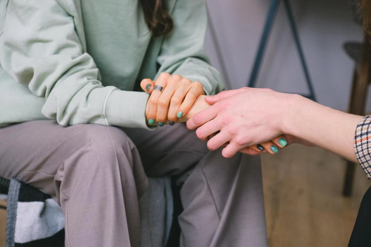 A person holding another persons hand to show support