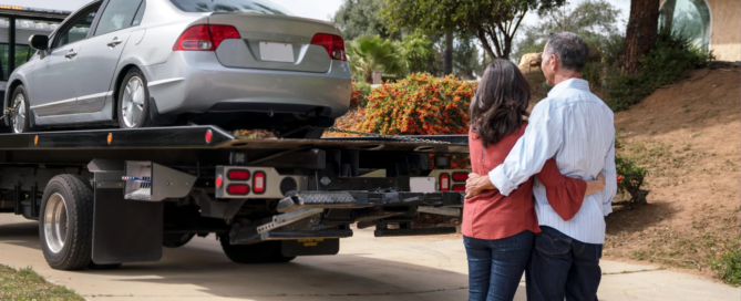 A couple hugs happily as their car is donated.