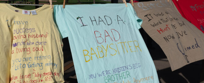 T-shirts sway gently on the line, each bearing messages about personal experiences related to babysitters, abuse, and family. Reach out to a local rape crisis center in Boston to get help and support for those affected by these profound stories.