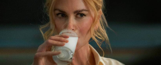 Nicole Kidman from the movie Babygirl, sipping from a glass of milk while wearing a light-colored shirt.