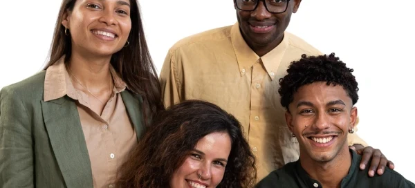 Four people are standing together and smiling against a plain background in coordinated, earth-toned outfits, united by their commitment to supporting Boston's community. They advocate for those in need and encourage all to get help when facing challenges.